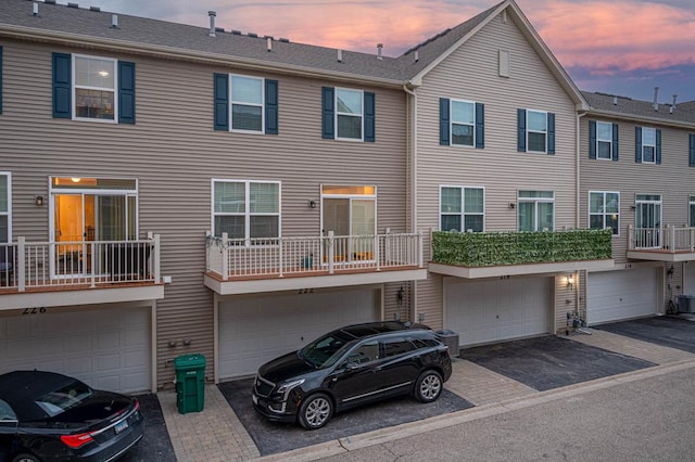 multi unit property featuring driveway and a garage