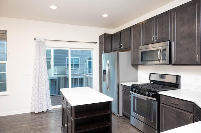 kitchen with dark brown cabinets, stainless steel appliances, light countertops, and dark wood-type flooring