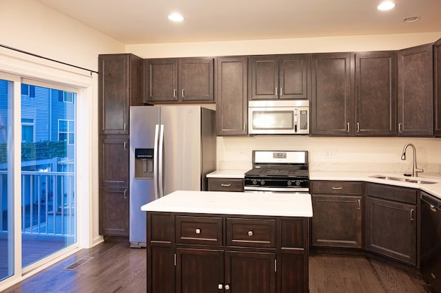 kitchen featuring dark brown cabinets, stainless steel appliances, dark wood-type flooring, and a sink