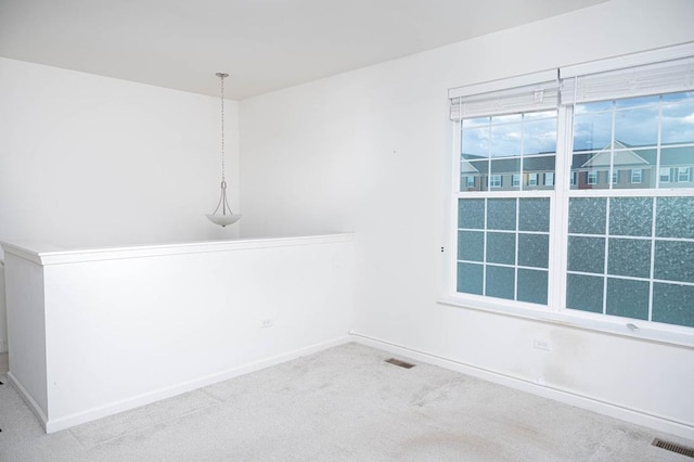 spare room featuring visible vents, baseboards, and carpet