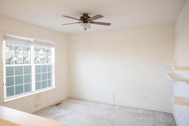 empty room featuring visible vents, carpet, baseboards, and ceiling fan