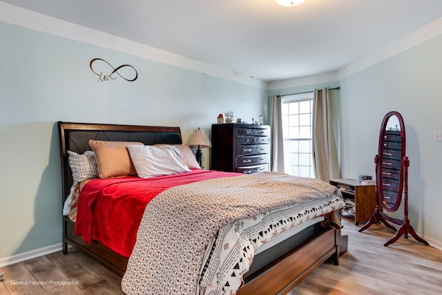 bedroom featuring wood finished floors and baseboards