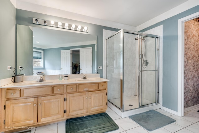 bathroom with double vanity, a stall shower, and a sink