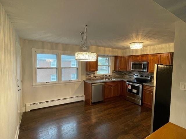 kitchen featuring stainless steel appliances, a sink, baseboard heating, tasteful backsplash, and brown cabinetry