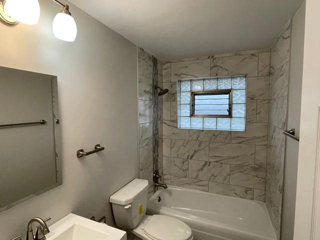 bathroom featuring toilet, shower / washtub combination, and vanity