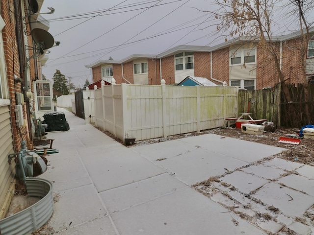 rear view of house featuring brick siding and fence