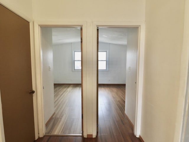 hall with dark wood finished floors and baseboards