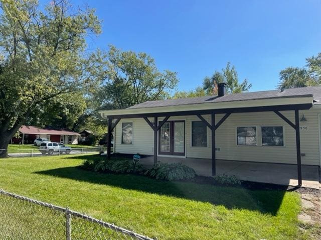 exterior space with a chimney, a front yard, and fence