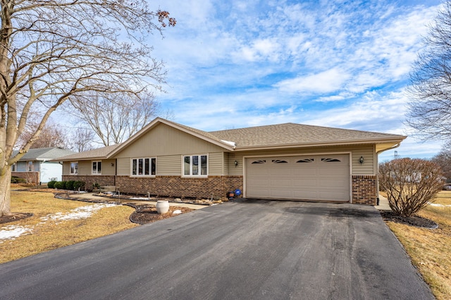 single story home with a garage, brick siding, roof with shingles, and aphalt driveway