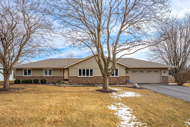 ranch-style house featuring an attached garage, driveway, a front yard, and brick siding