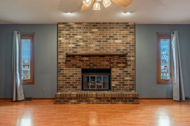 unfurnished living room with plenty of natural light, light wood-type flooring, and a fireplace