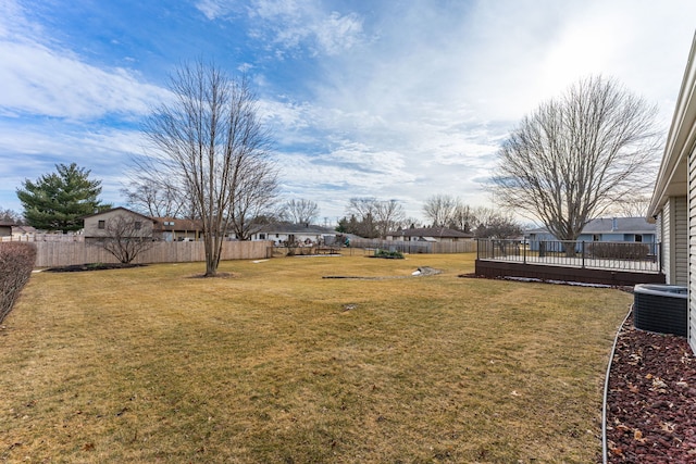 view of yard featuring cooling unit, a fenced backyard, and a residential view