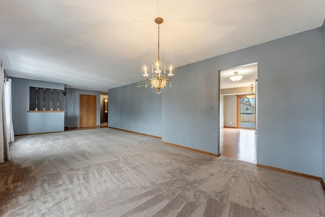 unfurnished room featuring baseboards, visible vents, a chandelier, and carpet flooring