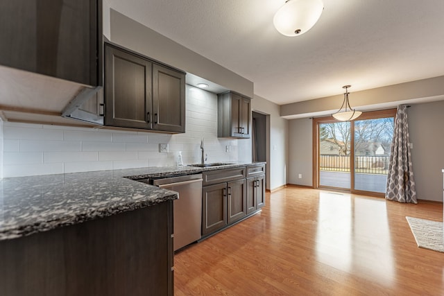 kitchen with a sink, dark brown cabinets, stainless steel dishwasher, dark stone counters, and decorative light fixtures