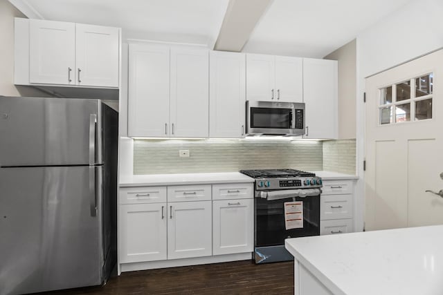 kitchen featuring dark wood finished floors, white cabinetry, stainless steel appliances, and backsplash