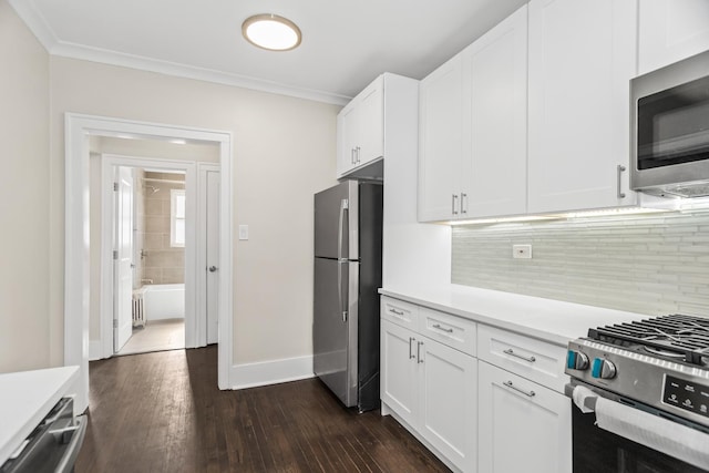 kitchen with white cabinets, appliances with stainless steel finishes, light countertops, and crown molding