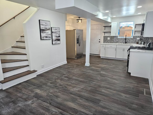 kitchen featuring stainless steel fridge, light countertops, white cabinetry, open shelves, and gas stove