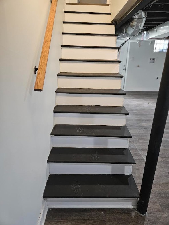 stairway featuring wood finished floors and baseboards