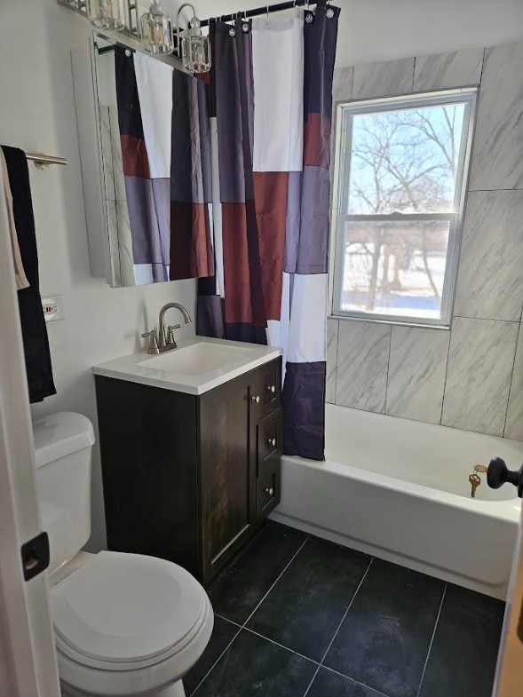 bathroom with shower / bathtub combination with curtain, vanity, toilet, and tile patterned floors