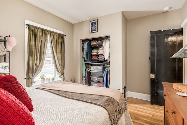 bedroom featuring baseboards, a closet, and light wood-style floors