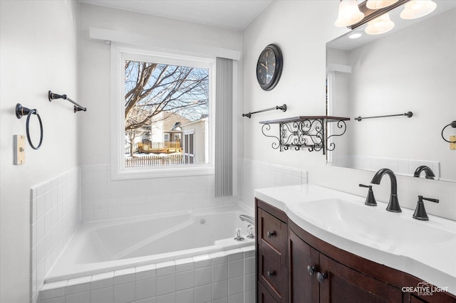 bathroom featuring a garden tub and vanity