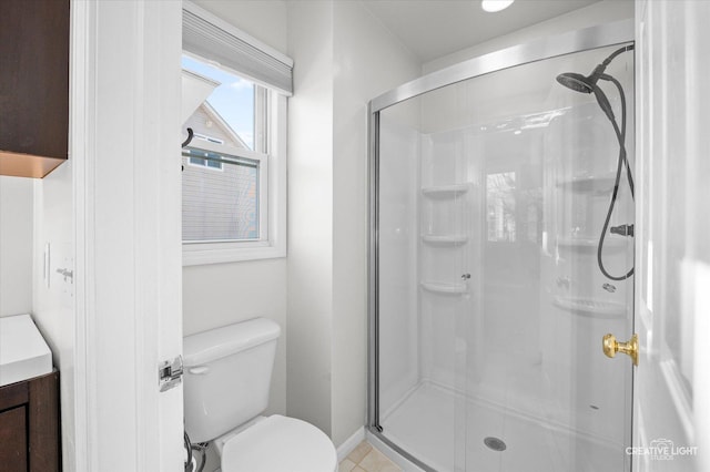 bathroom with vanity, a shower stall, and toilet