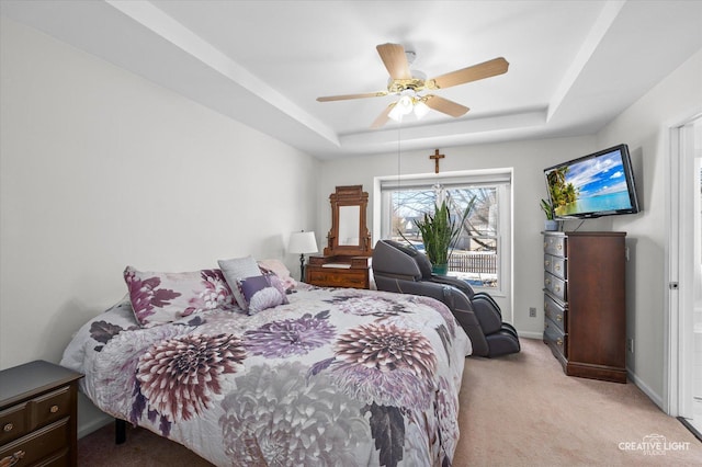 bedroom with baseboards, a tray ceiling, a ceiling fan, and light colored carpet