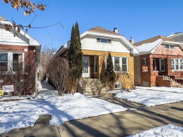 view of front of home featuring a chimney and brick siding