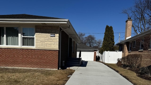 view of property exterior with a garage, stone siding, fence, and brick siding