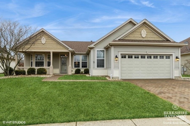 view of front of house with a garage, a front yard, decorative driveway, and covered porch