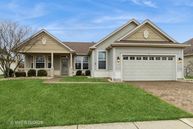 view of front of house with decorative driveway, roof with shingles, covered porch, a garage, and a front lawn