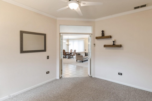 carpeted spare room featuring ceiling fan with notable chandelier, ornamental molding, visible vents, and baseboards