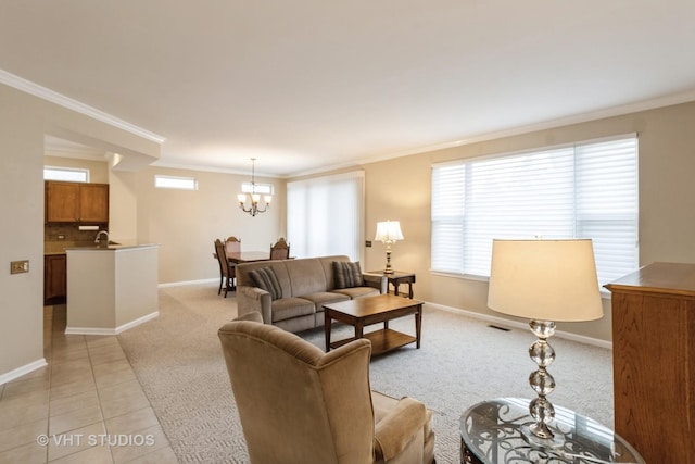 living room with baseboards, light colored carpet, ornamental molding, an inviting chandelier, and light tile patterned flooring