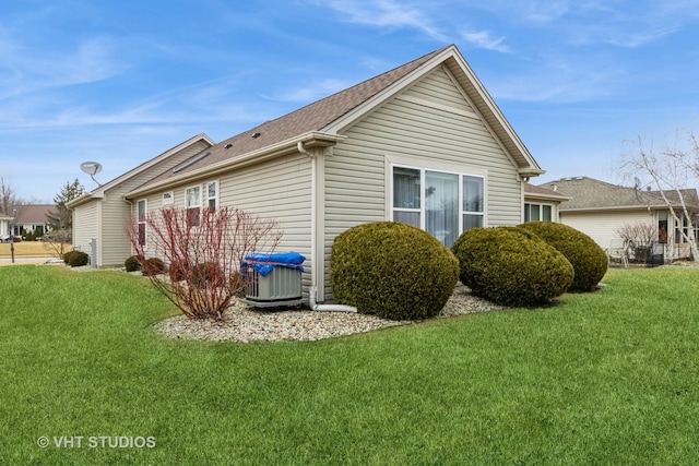 view of home's exterior with a lawn and central AC unit