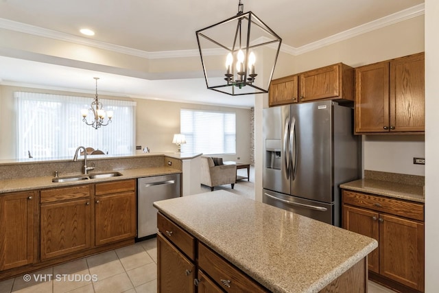 kitchen with a notable chandelier, a sink, ornamental molding, appliances with stainless steel finishes, and brown cabinetry