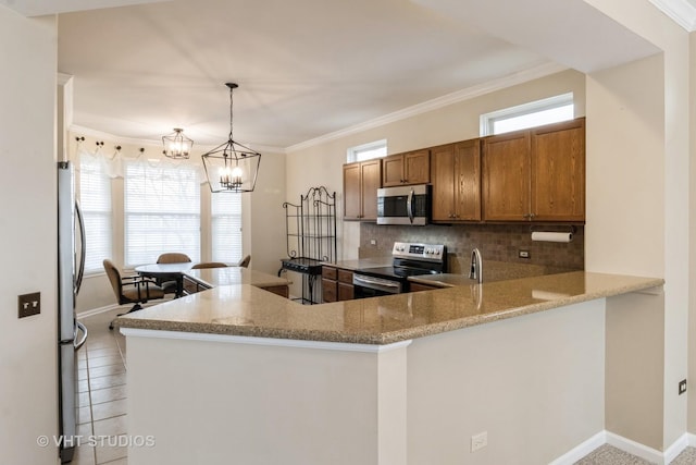 kitchen featuring stainless steel appliances, a peninsula, ornamental molding, decorative backsplash, and brown cabinets