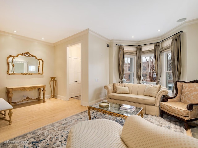 living area with light wood-type flooring, crown molding, baseboards, and recessed lighting