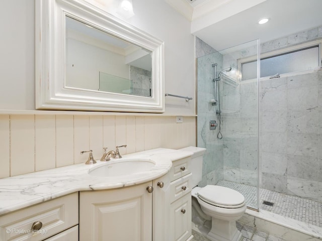 bathroom with crown molding, toilet, a stall shower, wainscoting, and vanity