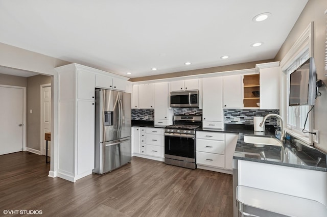 kitchen with dark wood-style flooring, open shelves, stainless steel appliances, white cabinetry, and a sink