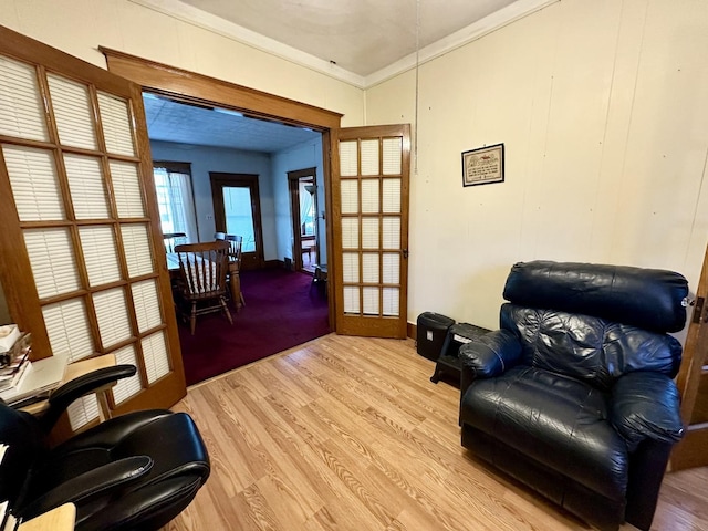 living area featuring light wood-style floors and ornamental molding