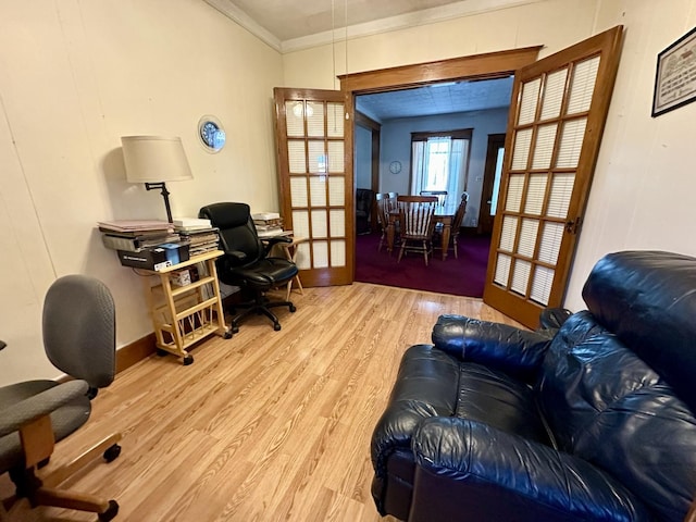 home office featuring french doors, crown molding, light wood-style flooring, and baseboards