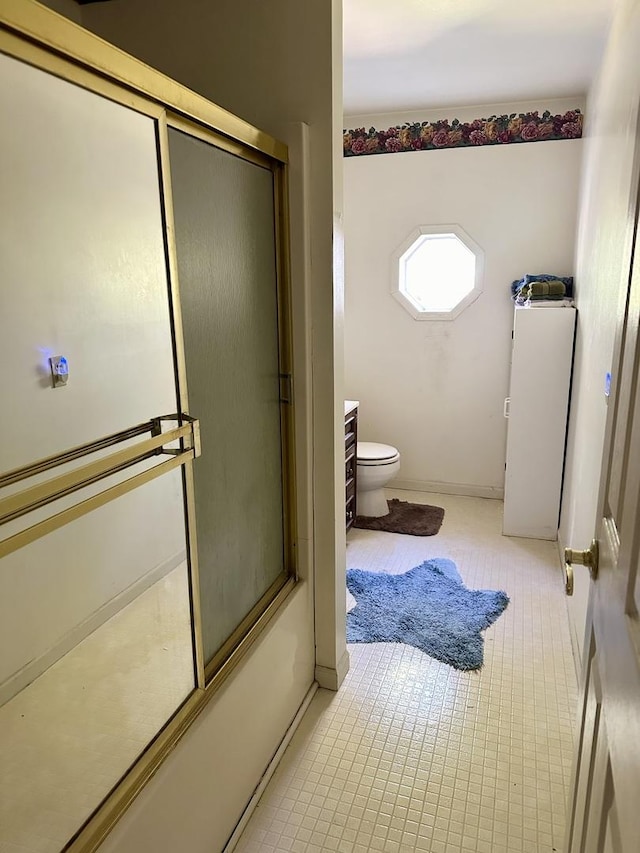 bathroom featuring enclosed tub / shower combo and toilet