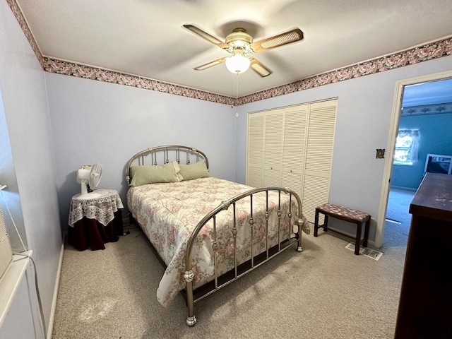 bedroom featuring a ceiling fan, a closet, and light colored carpet