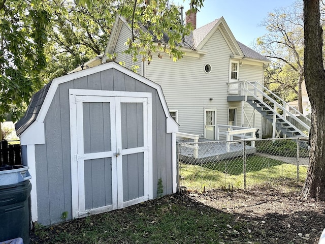 view of shed with fence and stairway