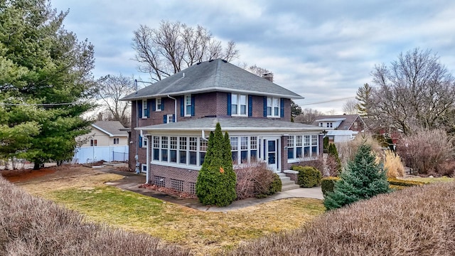 back of property with brick siding, fence, and a chimney