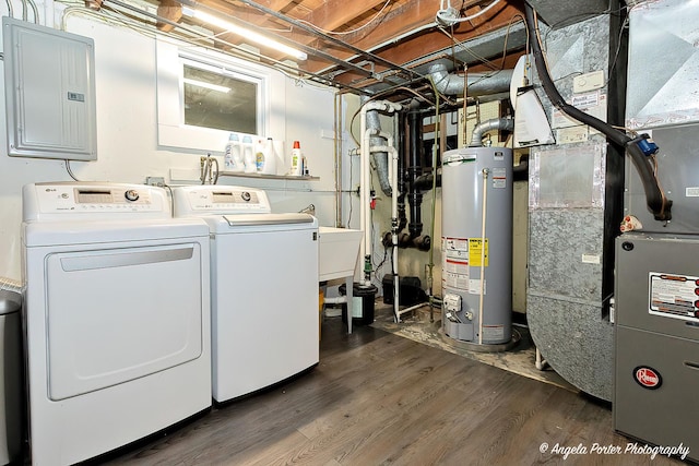 laundry room with laundry area, electric panel, dark wood finished floors, washing machine and dryer, and gas water heater