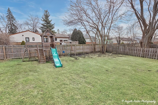 view of yard featuring a playground and a fenced backyard