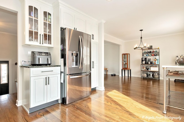 kitchen featuring white cabinets, glass insert cabinets, stainless steel refrigerator with ice dispenser, and crown molding