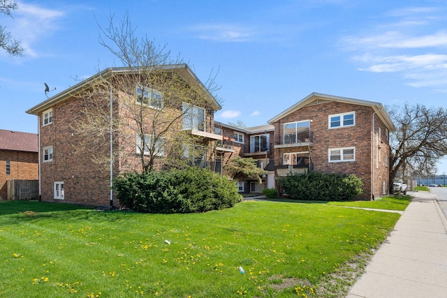 view of front of home with a front yard and brick siding