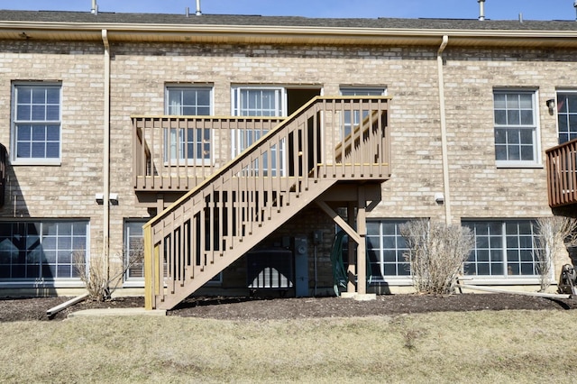 back of property featuring stairway, brick siding, and a wooden deck